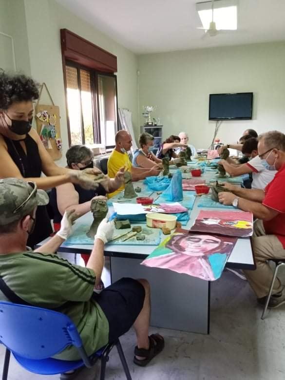 Gruppo di partecipanti dipinge e lavora la cartapesta al laboratorio