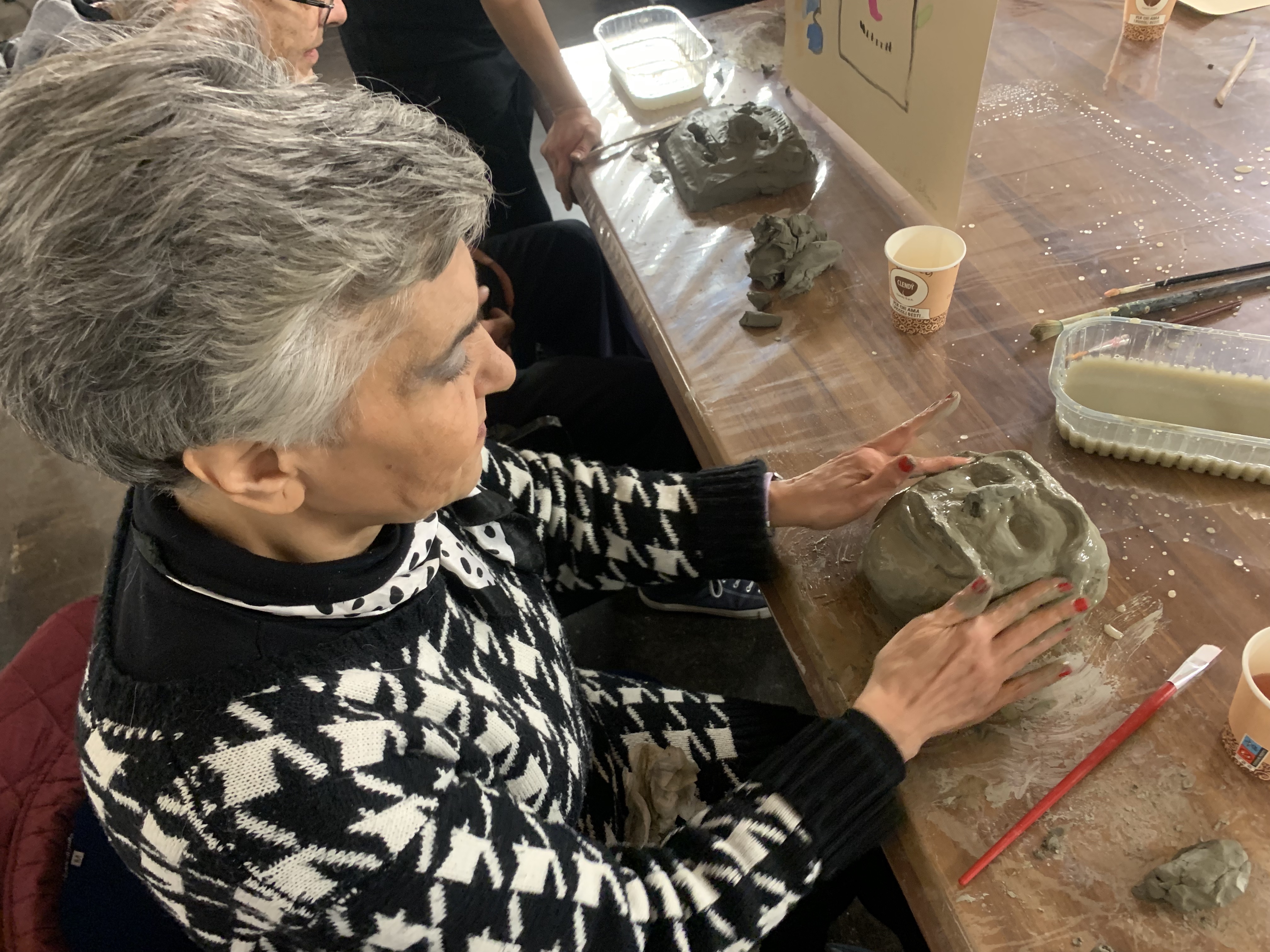 Partecipante al laboratorio di argilla modella una maschera